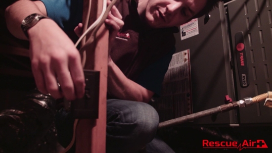 technician turning on furnace power switch