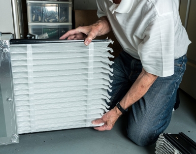 man putting in new furnace air filter