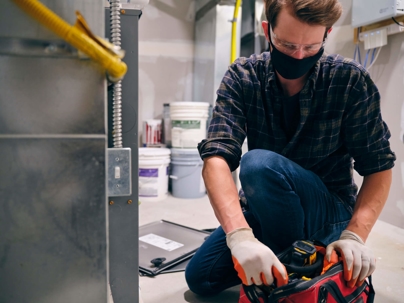 technician getting tools to repair a furnace