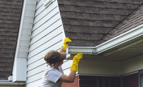 woman cleaning gutters